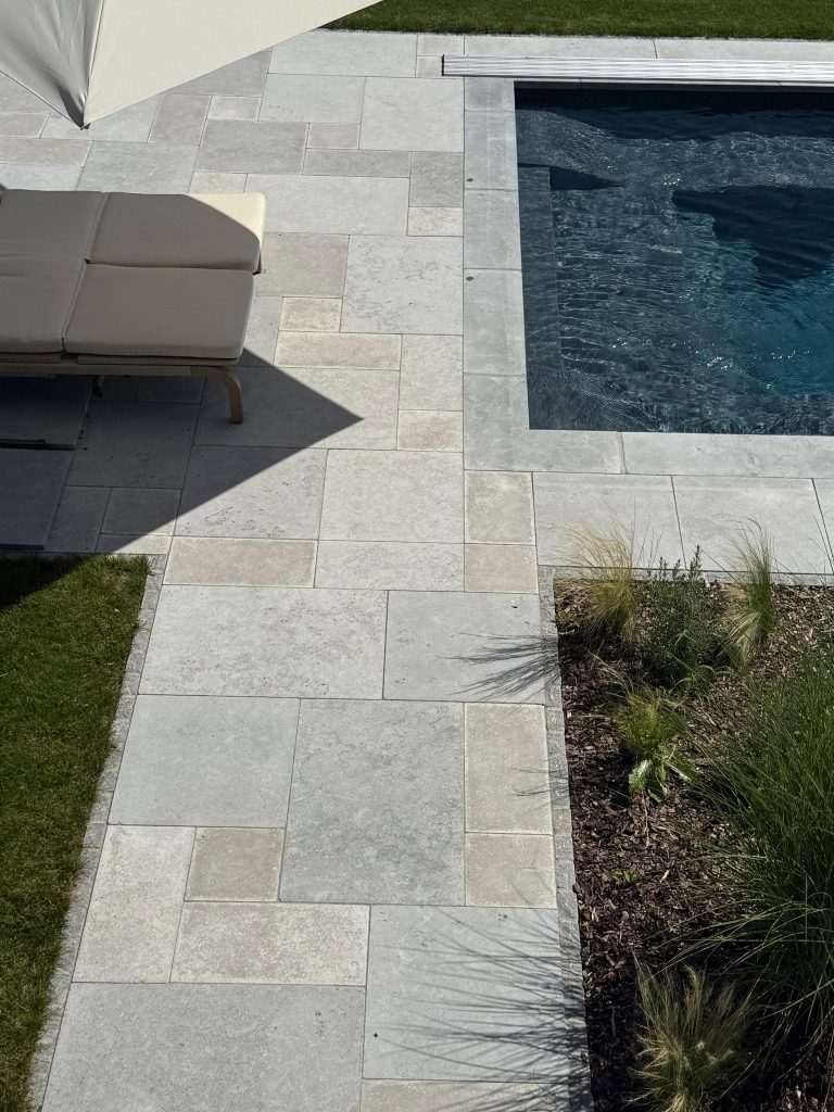 Naturstein im römischen Verband als Poolumrandung und Terrassenbelag